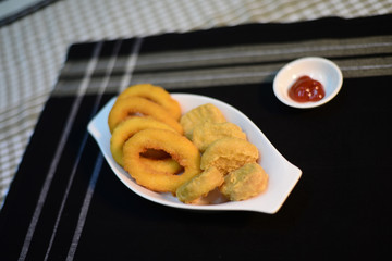 close up of a hand decorating entree on the bench in a professional kitchen