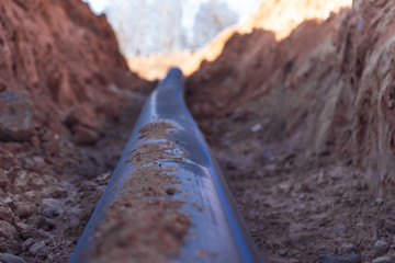 Fototapeta premium Plastic water pipe lay in a trench