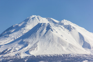 Fototapeta na wymiar Mount Shasta covered in snow in a blue sky