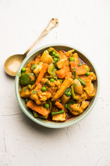 Mix vegetable curry - Indian main course recipe contains Carrots, cauliflower, green peas and beans, baby corn, capsicum and paneer/cottage cheese with traditional masala and curry, selective focus