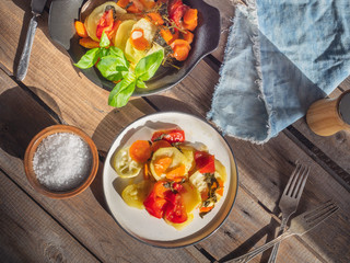Vegetable breakfast of zucchini with carrots and tomatoes, decorated with basil leaves