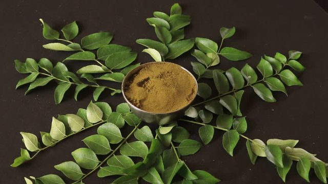 Bunch of curry leaves and power  over black background