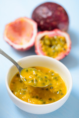 Passion fruit and juice in a bowl, top view