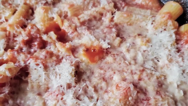 Fresh traditional and simple tomato sauce bubbling and cooking with pecorino romano cheese melting on top. Nonna's recipe.