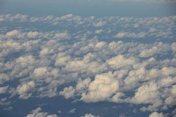 Fototapeta na wymiar 無数に雲が浮かぶ海上を、航空機から見下ろした風景