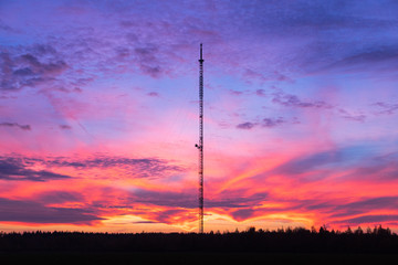 Telecommunication tower on a background of pink sunset