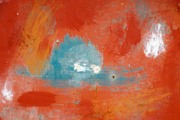 Rusty iron surface unevenly coated with red, white and blue paint with smudges