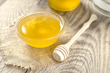 fragrant golden honey in a glass jar on a wooden table