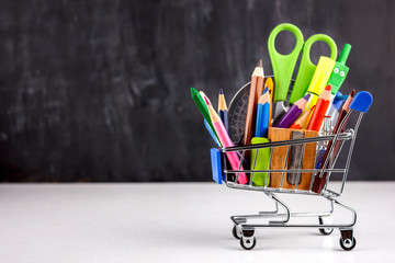 Set of colored pencils and markers for school. Stationery for the student - scissors, sharpener, eraser in a shopping cart