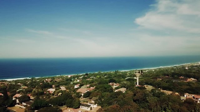 Aerial footage filmed by a Drone of Scottburgh Beach and Land grassy fields with residential houses overlooking the sea in Kwa Zulu Natal South Africa