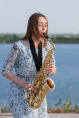 Young woman with saxophone in the park