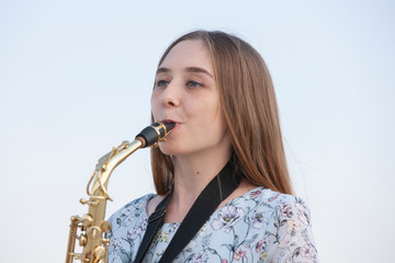 Young woman with saxophone with nature background