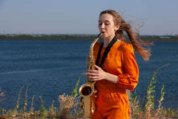 Young woman with saxophone in the park