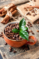 Cup full of coffee beans on wooden tableC