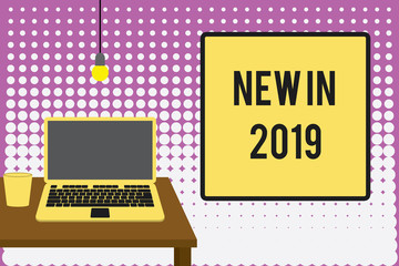 Conceptual hand writing showing New In 2019. Concept meaning what will be expecting or new creation for the year 2019 Front view laptop lying on wooden desktop light bulb glass