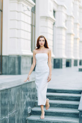  Summer look and white dress. Portraits of an elegant girl with luxury apartments.