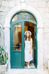 Summer photo shoot on the streets of Kotor, Montenegro. Beautiful girl in white dress and hat.