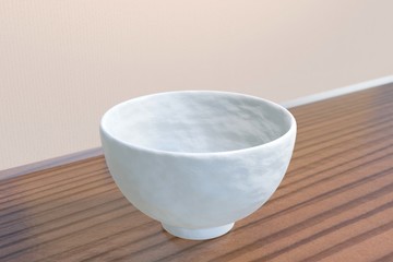 Japanese white rice bowl (empty) on a wood table (diagonal)
