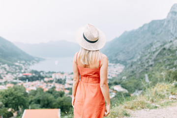 Summer photo shoot at sunset in Kotor, Montenegro. Beautiful girl in red dress and hat.