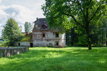 Collapsing two-story brick house in the park on a summer day