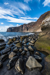 Fototapeta na wymiar Large stones at the foot of the coastal cliffs