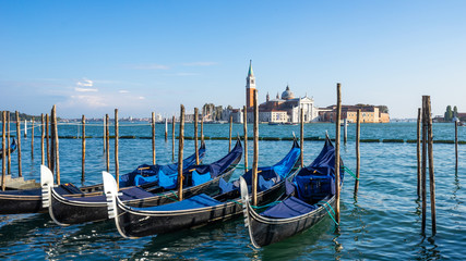 Fototapeta na wymiar Landscape view of gondola parked beside the Riva degli Schiavoni with San Giorgio di Maggiore church in background in Venice, Italy, Europe