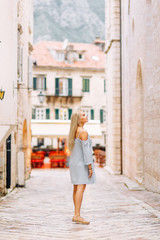 Beautiful girl with lights in Montenegro. Photo shoot on the evening and night streets of Kotor.