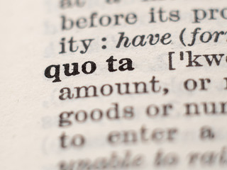 Dictionary definition of word Quota, selective focus.