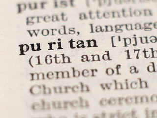Dictionary definition of word puritan, selective focus.
