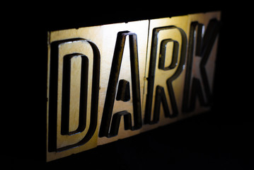 Old wood and steel number plate dies spell out the word DARK