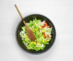 Healthy vegetable salad of fresh tomato, cucumber, onion, spinach, lettuce and sesame on plate. Diet menu
