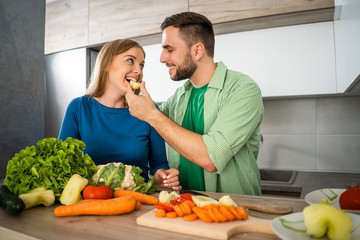 Young couple is preparing meal in their kitchen. 