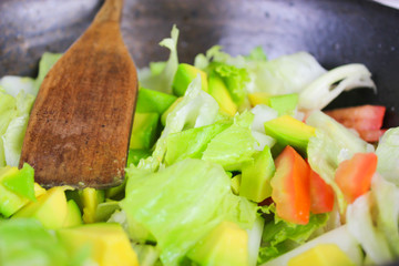 Healthy vegetable salad of fresh tomato, cucumber, onion, spinach, lettuce and sesame on plate. Diet menu