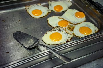 Scrambled eggs on a large stove in the cafe. Scrambled eggs from a few eggs.