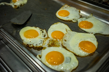Scrambled eggs on a large stove in the cafe. Scrambled eggs from a few eggs.