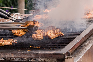 Meat is fried on the grill on the coals. Cook roasts meat on the coals.