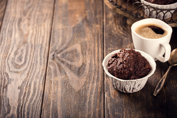 Tasty chocolate banana muffins on dark wooden table. Sweet mini cakes. Party food background with copy space.