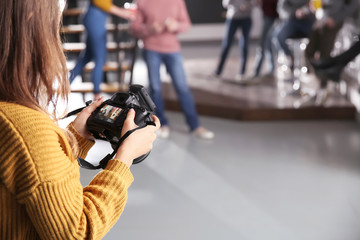 Woman taking photo of young coworkers during coffee break in cafe