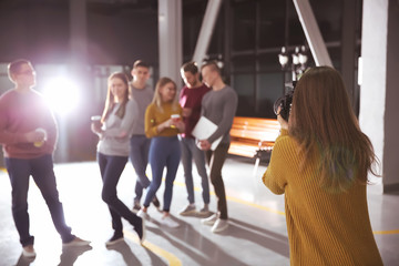 Woman taking photo of young coworkers during break