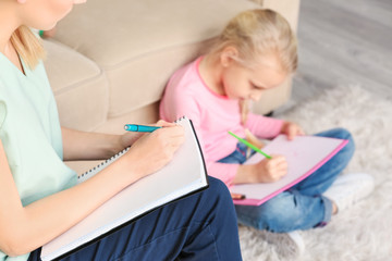 Female psychologist working with little girl in office