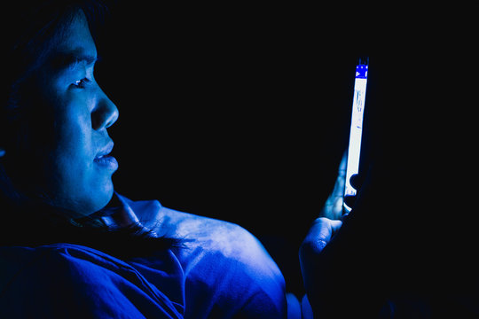 Women she played the smart phone in the dark light and the blue light has a negative effect on the eyes