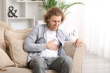 Obraz premium Young man suffering from chest pain at home