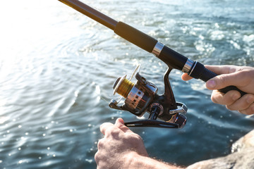 Young man fishing in river, closeup