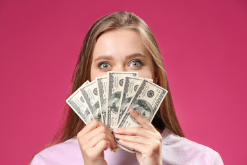 Excited woman with money on color background
