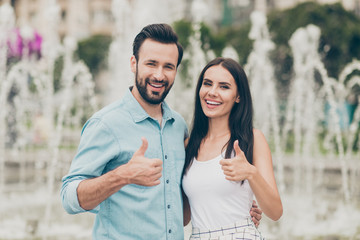 Obraz premium Portrait of cute lovely people married spouse have free time holiday weekend stroll fountain nature park town center trendy stylish handsome singlet shirt blue denim jeans outside bearded