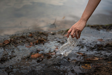 hand pick up plastic bottle from water