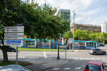 Barcelona, Spain - 26th July 2017 - Campus Nord sign post with moving tram behind