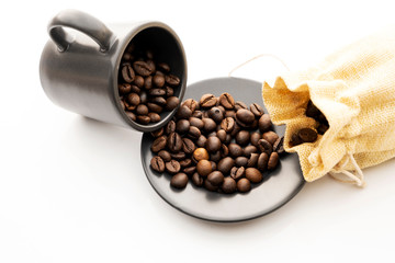 Coffee beans in cups and plates on a white background