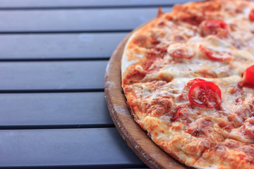 Whole pizza Margarita with tomatoes and cheese. Food on the beach
