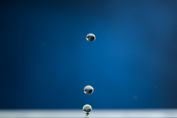 Obraz na płótnie Canvas Splash from a drop of water on a blue background macro, falling drop